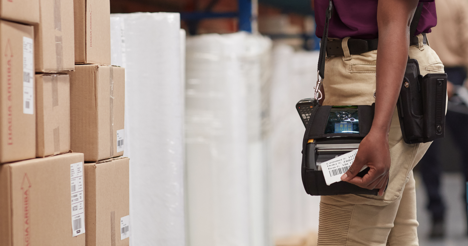 Person using mobile printer in warehouse for cannabis inventory management.